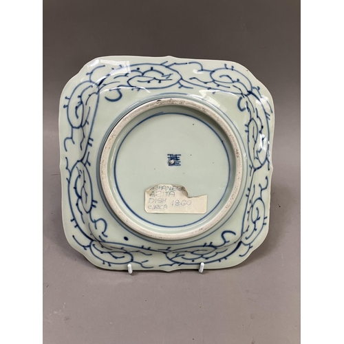 24 - A Japanese Arita dish, square outline painted to the centre in under glazed blue with island pavilio... 