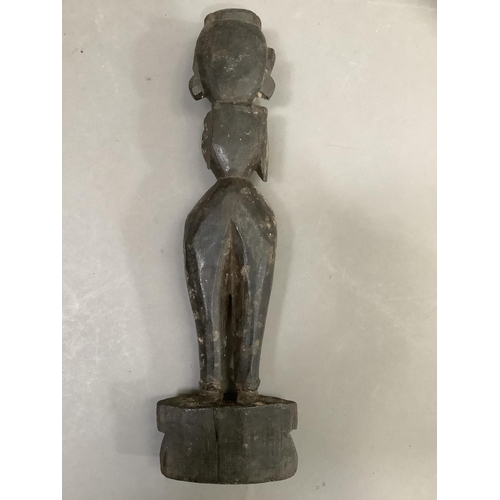 56 - A Indian carved hardwood figure of a woman, having a carved coiffure, narrow waist in ceremonial dre... 