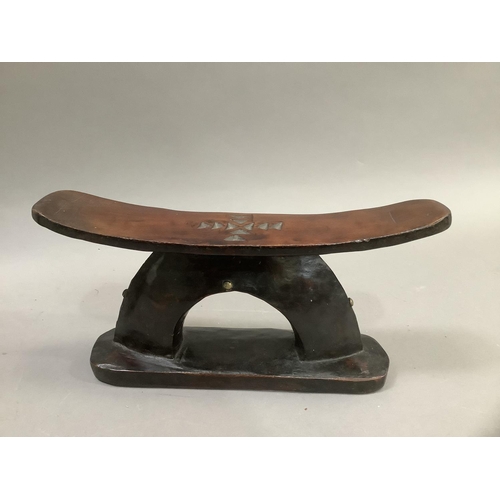 60 - An African hardwood headrest having carved decoration to rest of a cross, the support formed of a ha... 