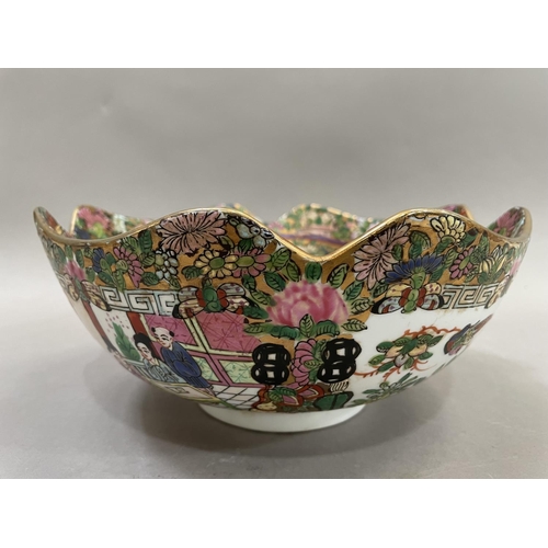 64 - A Chinese famille rose bowl having a border of gilding to the scalloped edge, enamelled with figures... 