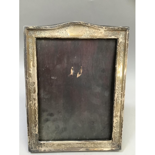 259 - A George V silver photograph frame, of rectangular arched outline, engraved with leaf scrolls, Chest... 