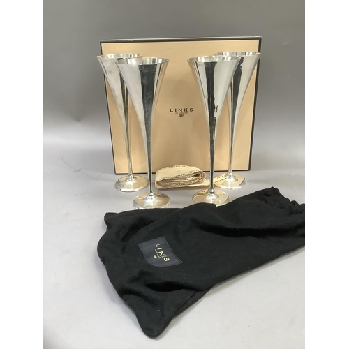 69 - A Links London set of four silver plated champagne flutes, in individual cloth bags, boxed