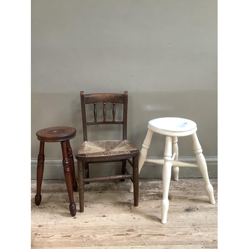 131 - A child's rush seated elm chair together with two three legged milking stools