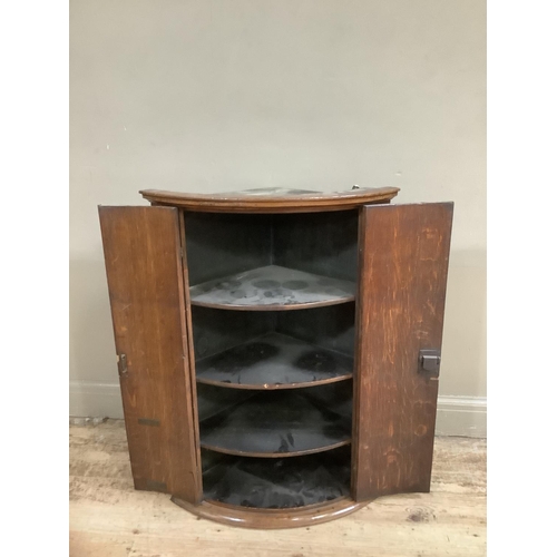 137 - A 19th Century bow-fronted, cross-banded oak and mahogany cross banded hanging corner cupboard