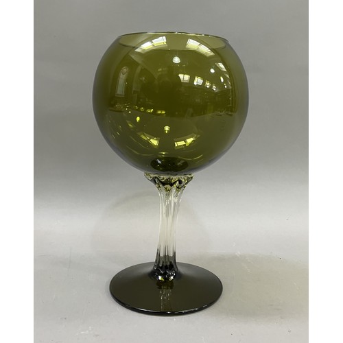 22 - A mid 20th century olive green glass goblet-shaped vase, the balloon bowl on a clear drawn stem and ... 