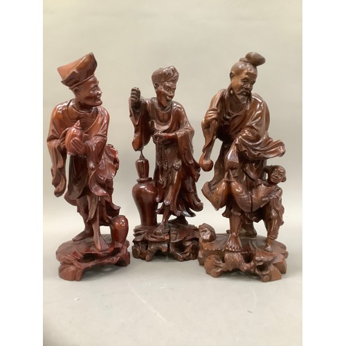 76 - Three Chinese root carvings, one of a fisherman and two further deities, 30cm high