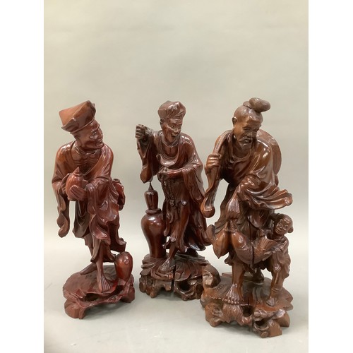 76 - Three Chinese root carvings, one of a fisherman and two further deities, 30cm high