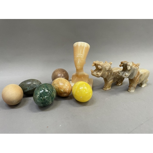 187 - Two carved alabaster hippos, a carved Egyptian head, four agate eggs and two carved wooden eggs