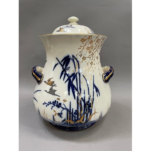 83 - A large lidded twin handled tureen, the body painted with waterfowl above a river with bamboo in blu... 