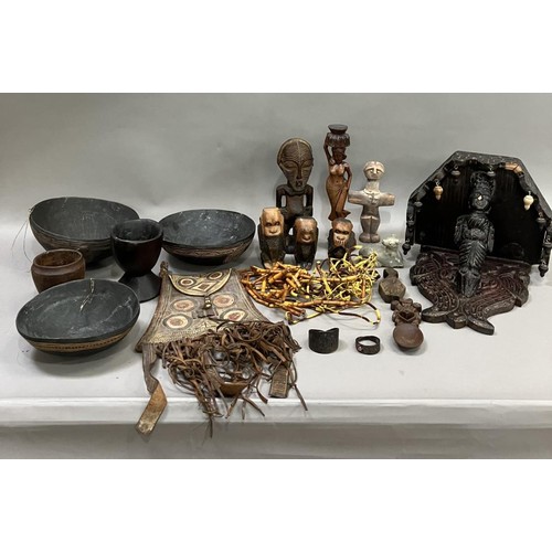 128 - A collection of carved tribal and Indian items including a carved sconce with hanging drops supporte... 