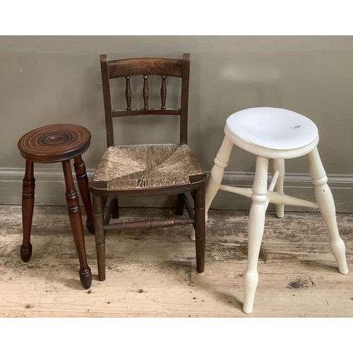 131 - A child's rush seated elm chair together with two three legged milking stools