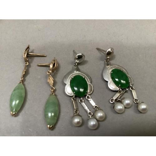 287 - A pair of jade and seed pearl ear pendants, each claw set to the centre with an oval cabochon over t... 