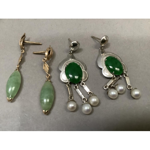 287 - A pair of jade and seed pearl ear pendants, each claw set to the centre with an oval cabochon over t... 