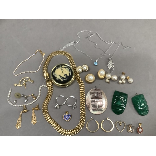 286 - A small collection of costume jewellery with two malachite carved masks, oval abalone shell pendant ... 