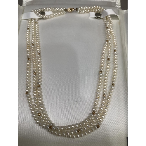 294 - A fresh water cultured pearl necklace of three  rows 4.5mm, pearls interspersed with small circular ... 