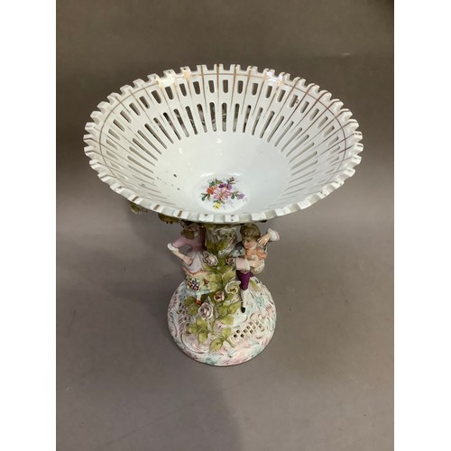 98 - A continental porcelain pedestal dish, the bowl formed as a flower encrusted pierced basket, the sup... 