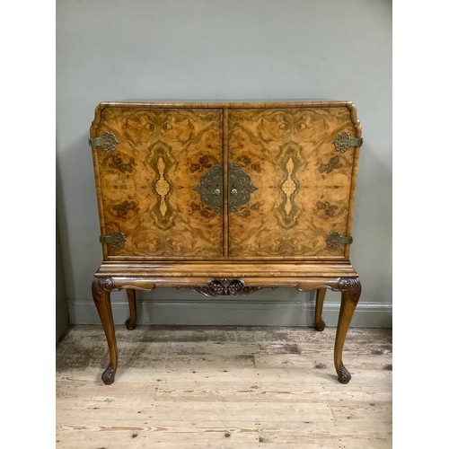 331 - A mid 20th century burr walnut drinks cabinet, having gilt metal mounts , fitted interior above a ca... 