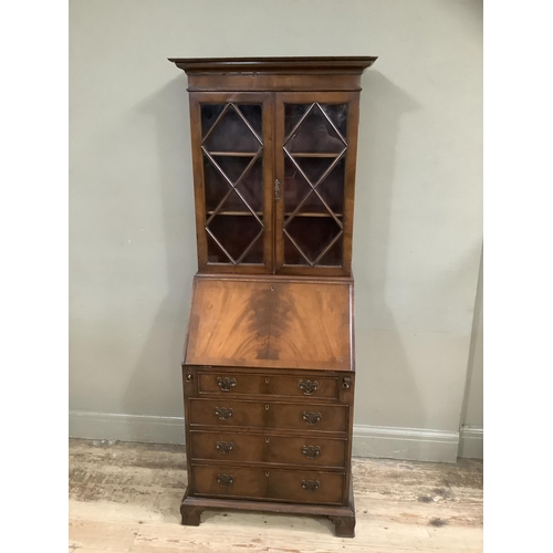 322 - A reproduction mahogany dwarf bureau bookcase having a pediment top, two glazed doors, fall front wi... 