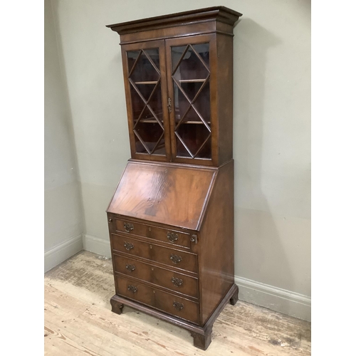 322 - A reproduction mahogany dwarf bureau bookcase having a pediment top, two glazed doors, fall front wi... 