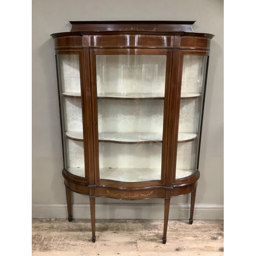 323 - An Edwardian mahogany inlaid and cross-banded display cabinet of serpentine bowed outline, short rai... 