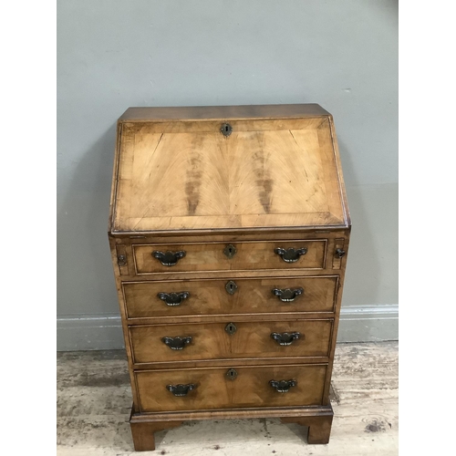 328 - A reproduction walnut bureau having a fall front with a fitted interior, above four graduated drawer... 