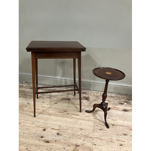 334 - An Edwardian mahogany cross-banded fold over card table on tapered legs together with a tripod wine ... 