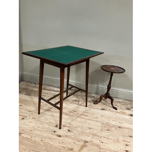 334 - An Edwardian mahogany cross-banded fold over card table on tapered legs together with a tripod wine ... 