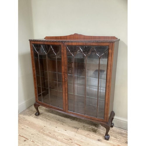 336 - A mid 20th century mahogany display cabinet with short raised carved back, glazed tracery doors with... 