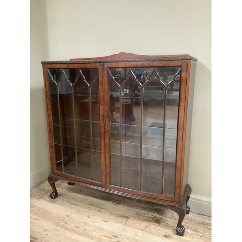 336 - A mid 20th century mahogany display cabinet with short raised carved back, glazed tracery doors with... 