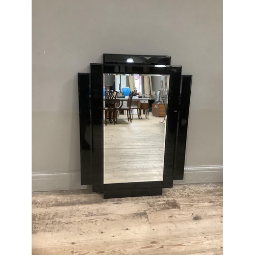 340 - A mid-century rectangular wall mirror with bevelled glass the frame formed of black perspex geometri... 