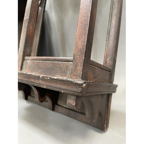 359 - An oak Indian style wall shelf bracket having carved arched windows together with another, 32cm wide... 