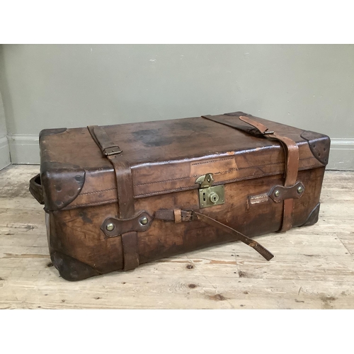 361 - A large vintage leather suitcase with straps, 84cm wide