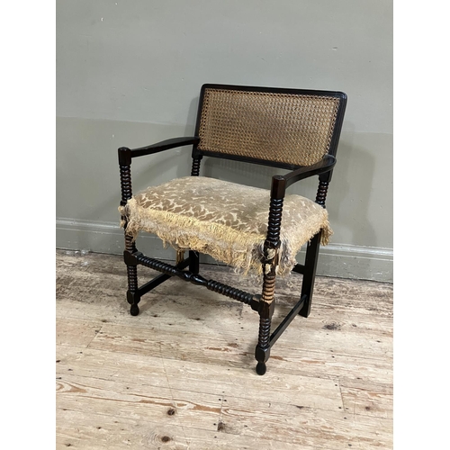 369 - An ebonised bobbin turned armchair having cane back on bobbin framing with with upholstered seat