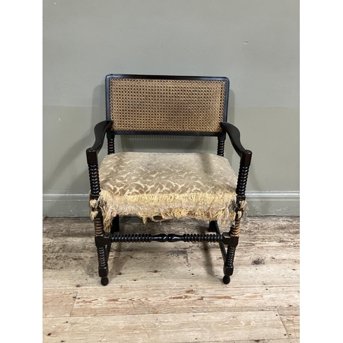 369 - An ebonised bobbin turned armchair having cane back on bobbin framing with with upholstered seat