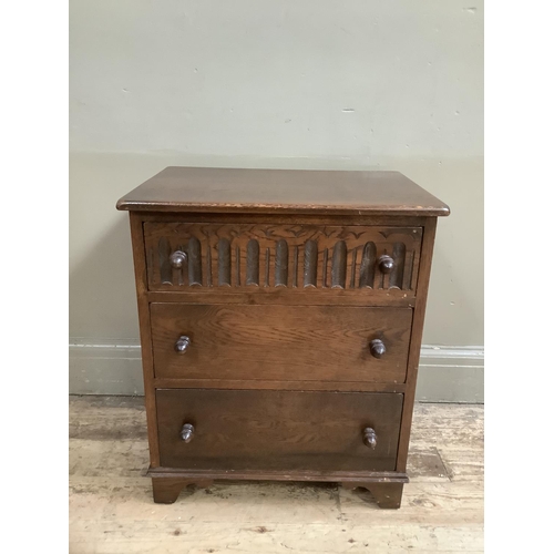 371 - An oak Old Charm style three height chest of drawers, the top drawer with carved front and on bracke... 