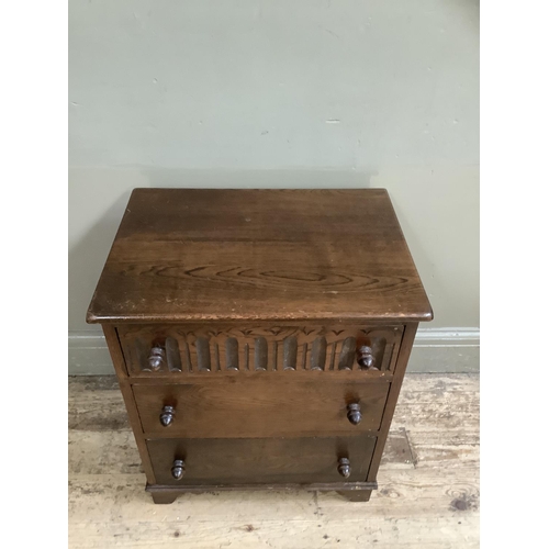 371 - An oak Old Charm style three height chest of drawers, the top drawer with carved front and on bracke... 