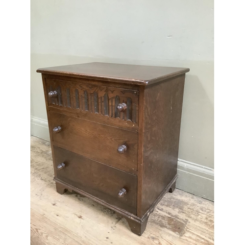 371 - An oak Old Charm style three height chest of drawers, the top drawer with carved front and on bracke... 