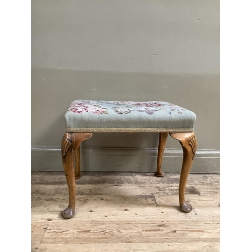 387 - A walnut dressing stool on cabriole legs with shell carvings to the shoulder with tapestry upholster... 