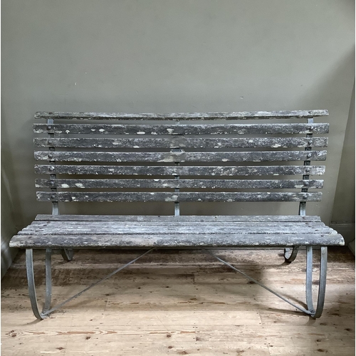 394 - A garden bench on metal scrolls supports 152cm wide