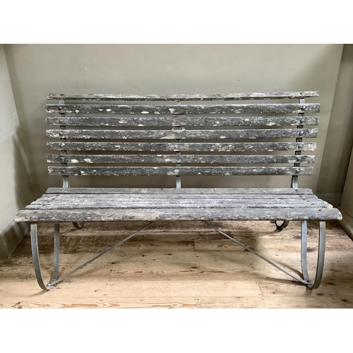 394 - A garden bench on metal scrolls supports 152cm wide