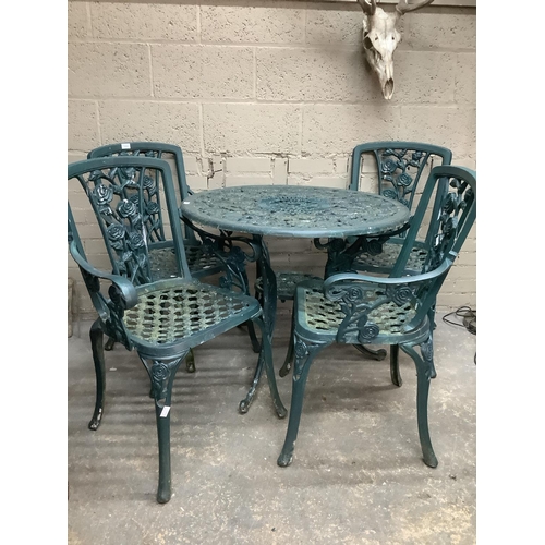 175 - A green cast iron garden circular table and four chairs