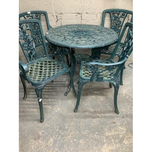 175 - A green cast iron garden circular table and four chairs