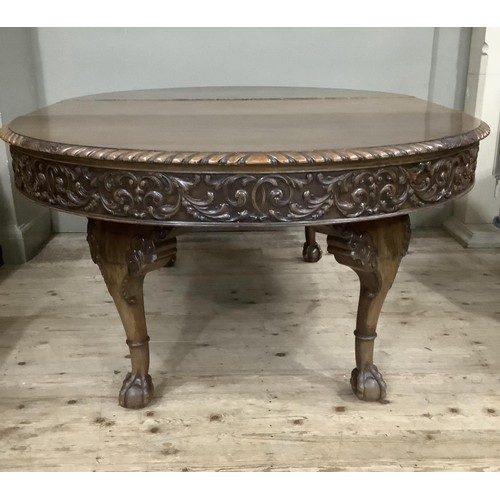 362 - An early to mid 20th century mahogany extending oval dining table, with one extra leaf, having a gad... 