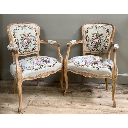 388 - A pair of continental walnut open armchairs having carved aprons on cabriole legs with tapestry upho... 