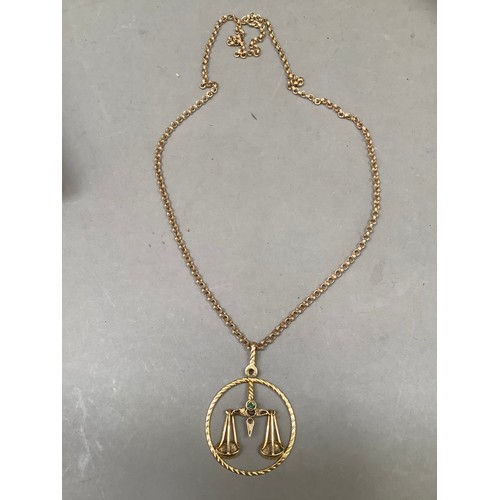 270B - A Libra Zodiac star sign pendant in 9ct gold, the scales in relief with a circular rope twist surrou... 