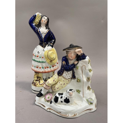 15 - A Staffordshire porcelaneous figure of a man in hat reclining against a stump with dog, together wit... 