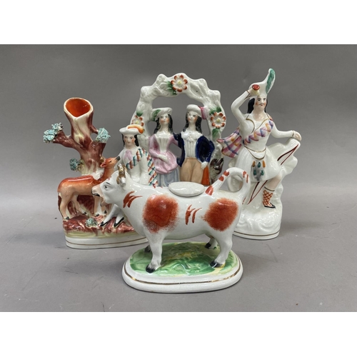 19 - A 19th century Staffordshire cow creamer with lid together with a Staffordshire flatback of a couple... 