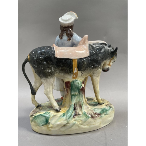 20 - A Staffordshire pottery figure of a girl with donkey on grassy mound, 25cm high