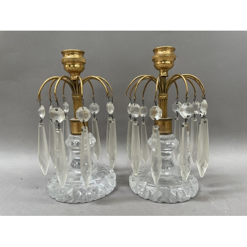 38 - A pair of gilt metal and cut glass lustres candlesticks, having arms issuing prismatic drops, 18cm h... 