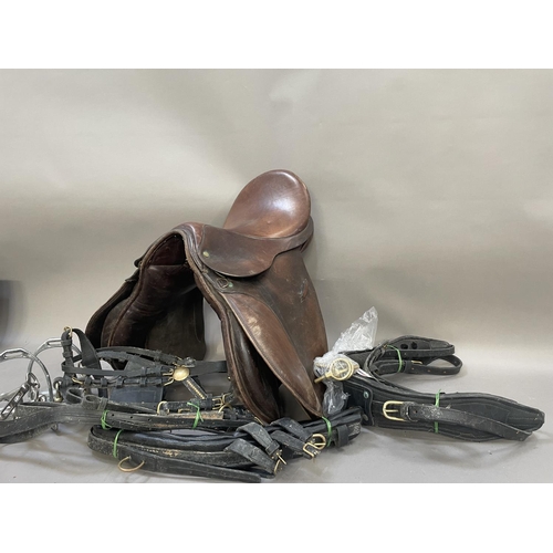 485 - A leather saddle stamped Britannia together with a bridle, reins bit and stirrups